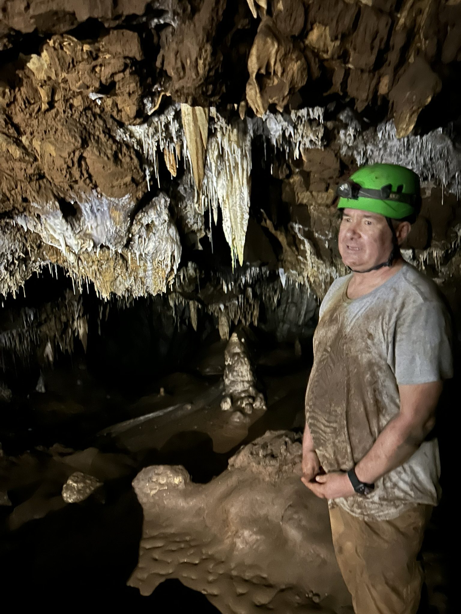 Guide with headlamp lecturing in the cave