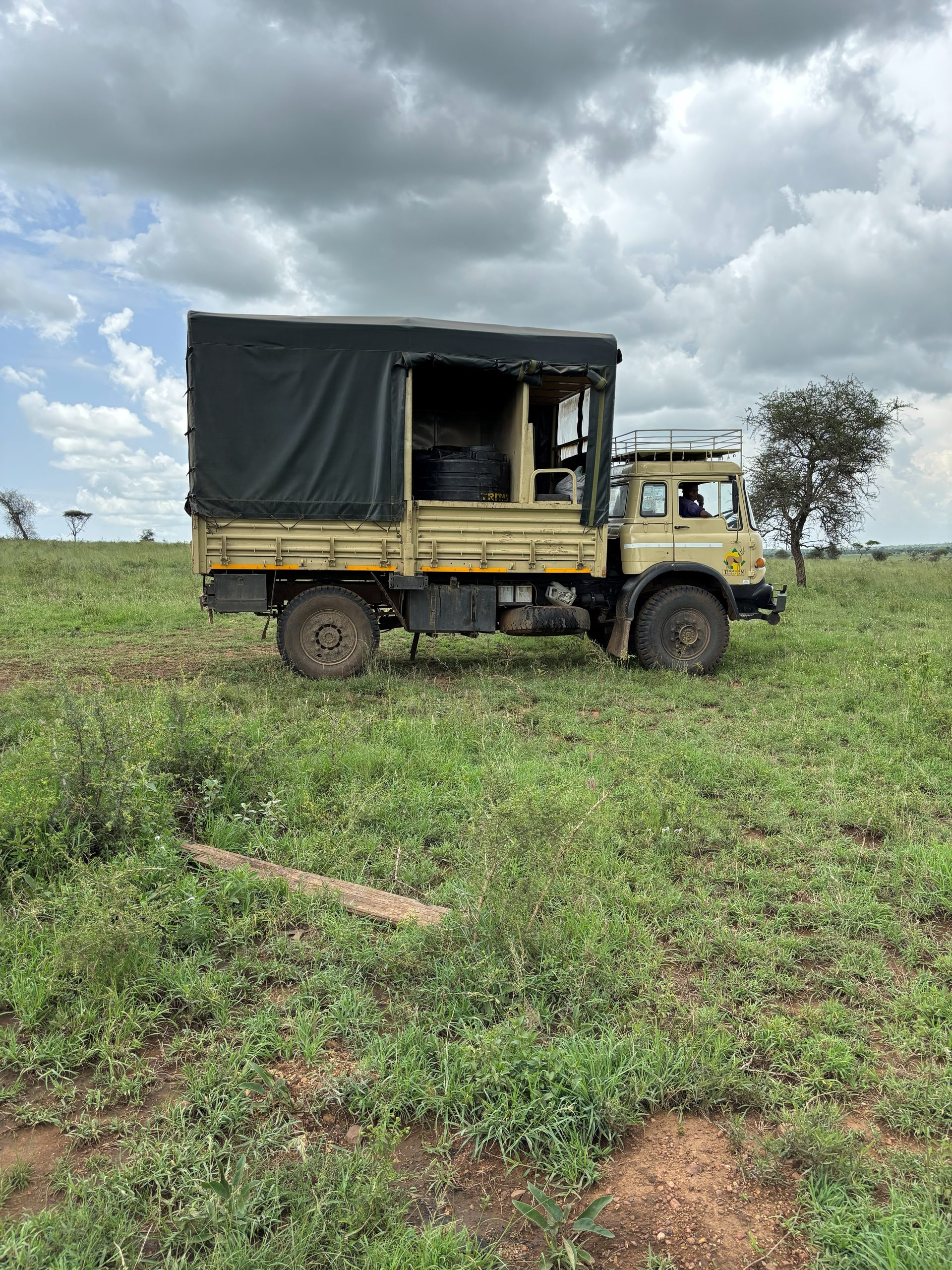The Thomson Safaris supply truck — a heavy-duty canvas-topped lorry parked on the Serengeti plain, carrying all camp equipment between sites