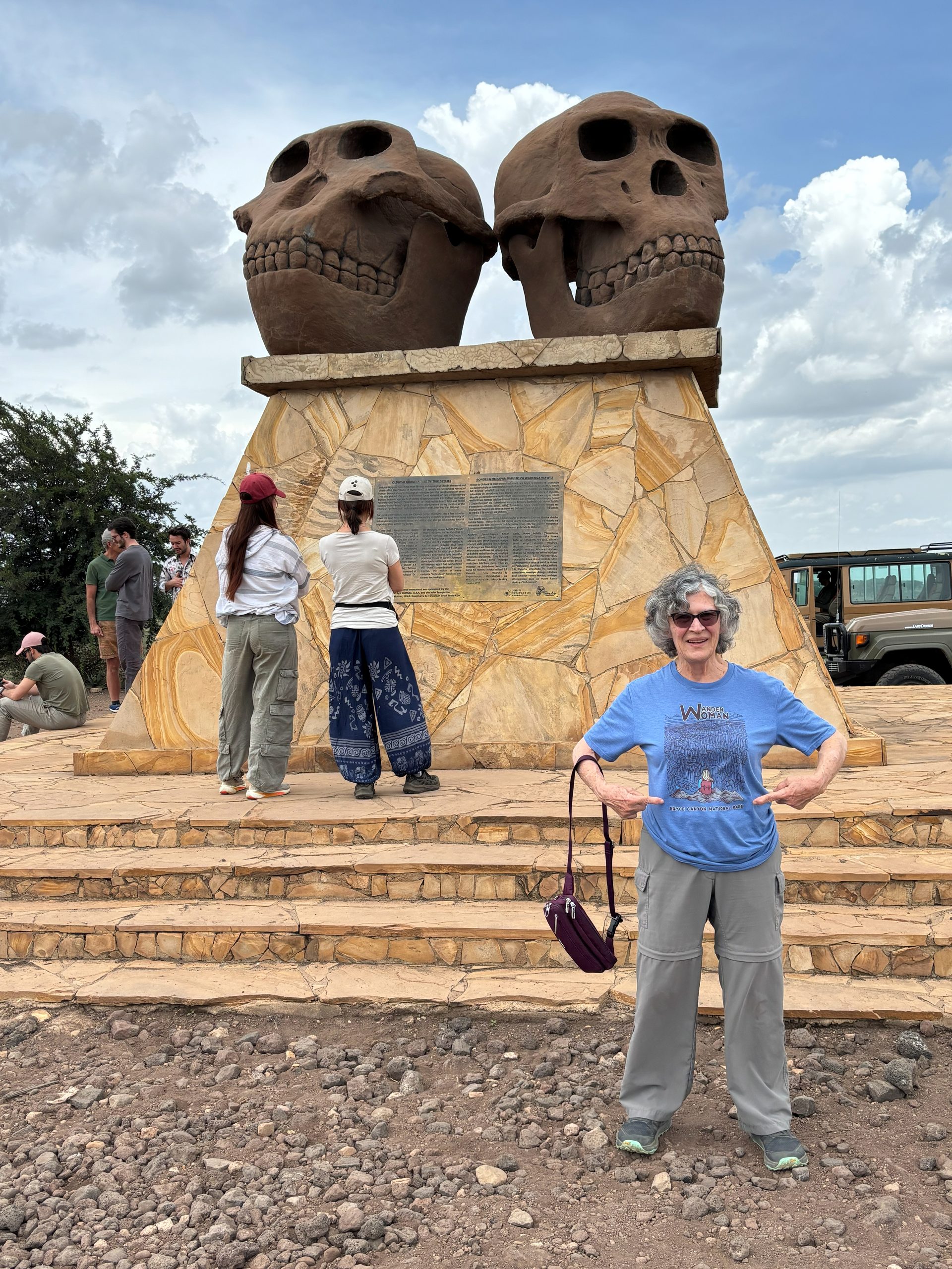 Jo posing hands-on-hips triumphantly at the Olduvai Gorge skull monument